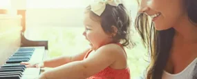 Mother letting toddler play on piano