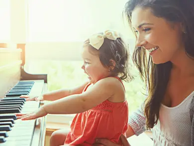 Mother letting toddler play on piano