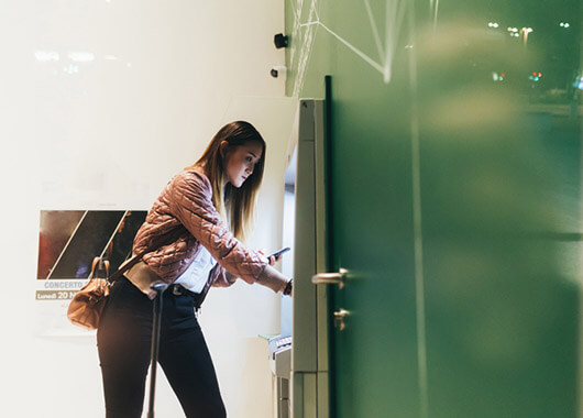 Woman taking money out of an ATM.