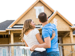 Couple in front of new home under construction