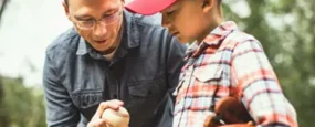 Dad showing son how to hold a baseball