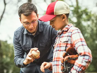 Dad showing son how to hold a baseball