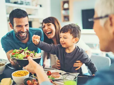 Family laughing while eating dinner