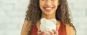 Young adult holding a piggybank