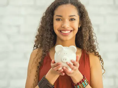 Young adult holding a piggybank