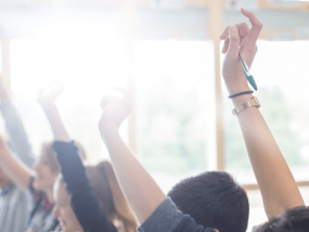 high school students in personal finance class raise hands