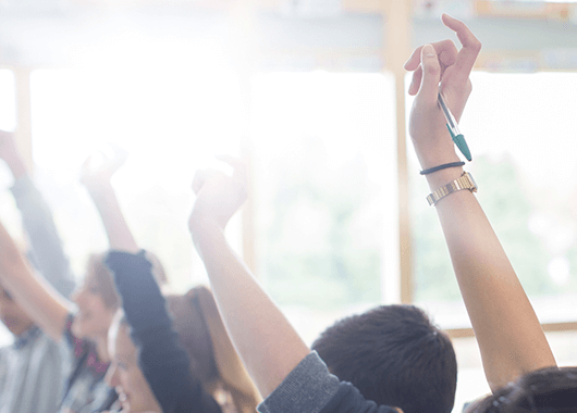 high school students in personal finance class raise hands