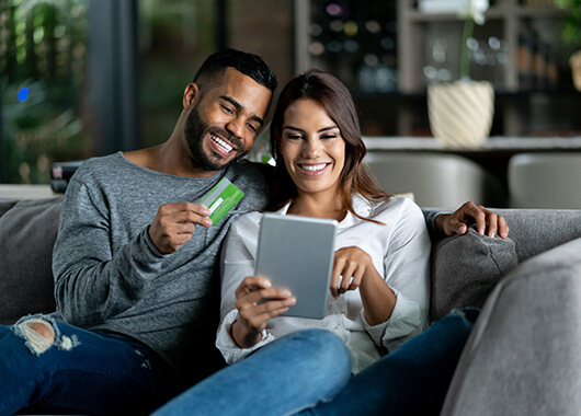 Couple using credit card for online purchase