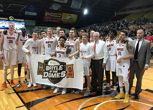 Idaho State University Basketball Players with Battle of the Domes sign