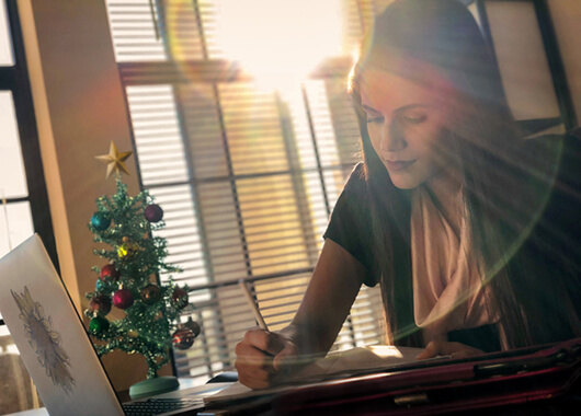 Woman looking at paperwork and computer