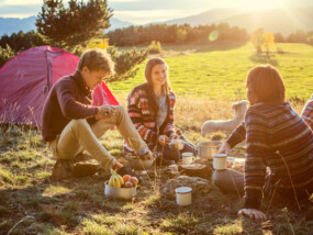 Group of young adults camping on a hillside