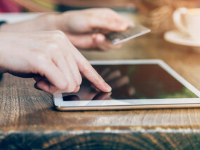 woman pays by credit card for online purchase on a tablet computer.