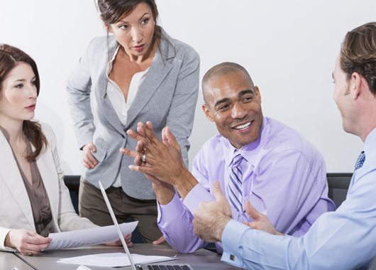 Multi-ethnic group of business people meeting in board room.