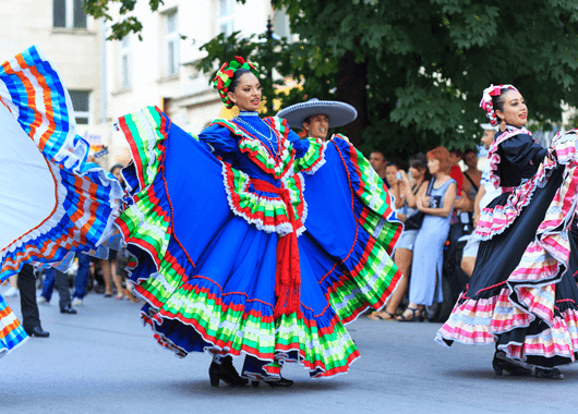 Hispanic women walking in parade.