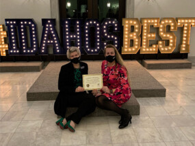 Two women sitting with the Best Credit Union Award