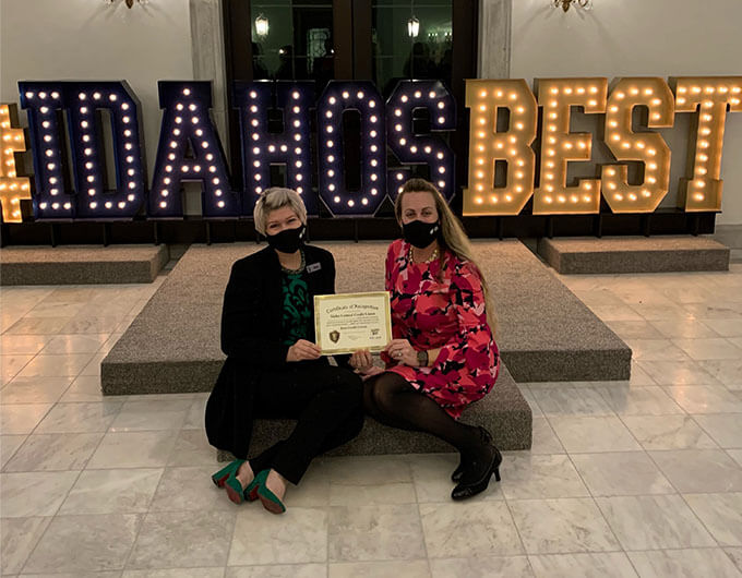 Two women sitting with the Best Credit Union Award