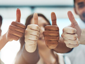 small business employees giving the thumbs up in approval of their company