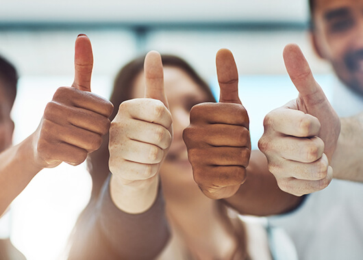 small business employees giving the thumbs up in approval of their company