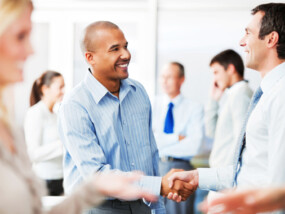 Happy business colleagues greeting each other with a handshake