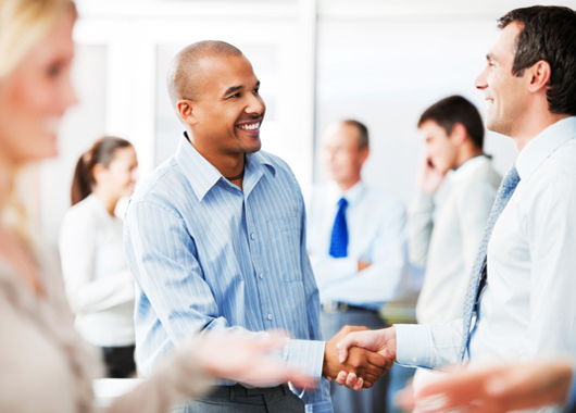 Happy business colleagues greeting each other with a handshake