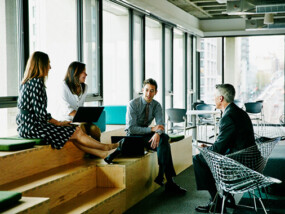 Business people talking casually on some benches.