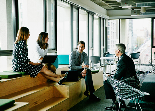 Business people talking casually on some benches.