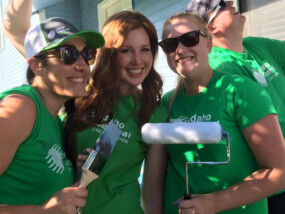 ICCU Team members holding paintbrushes and rollers during Paintfest.