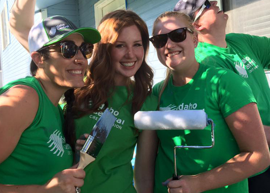 ICCU Team members holding paintbrushes and rollers during Paintfest.