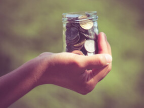 hand holding jar of coins|hand holding jar of coins