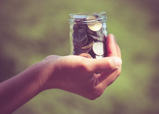 hand holding jar of coins|hand holding jar of coins