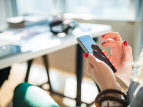 Close up of woman chatting with friends on a mobile phone.