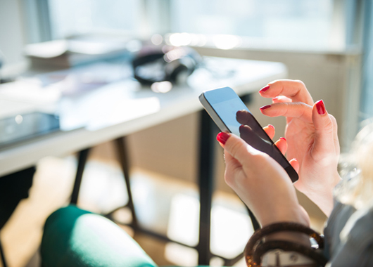 Close up of woman chatting with friends on a mobile phone.