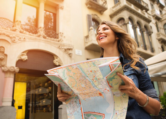 Girl holding a map outside of a building while she travels abroad.