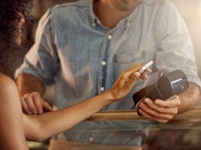 Cropped shot of a customer paying using a smart phone and an electronic reader