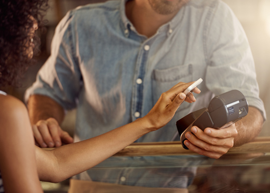 Cropped shot of a customer paying using a smart phone and an electronic reader