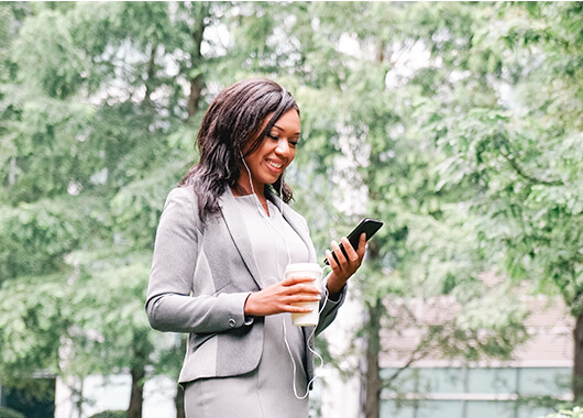 Woman employee talking on her cell phone outside with a headset.