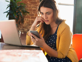 worried woman looking at cell phone