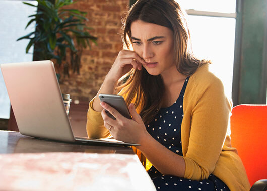 worried woman looking at cell phone