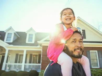 Dad with Daughter sitting on his shoulders smiling