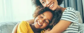 Women and daughter laughing and hugging