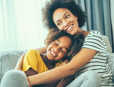 Women and daughter laughing and hugging