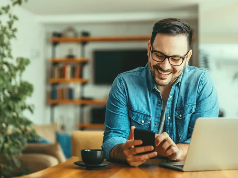 Man smiling while browsing his phone