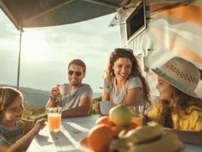 Family eating dinner outside their RV