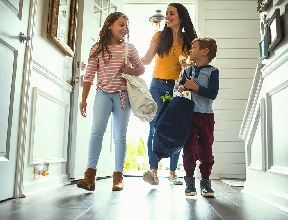 Family walking through the front door smiling