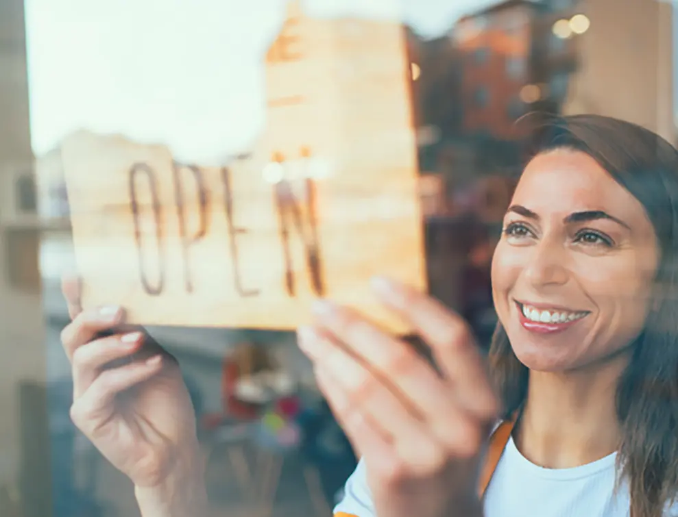 Women with an open sign for her business