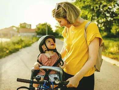 Women pushing her son on a bike