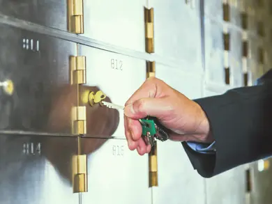 Someone putting a key in a safe deposit box