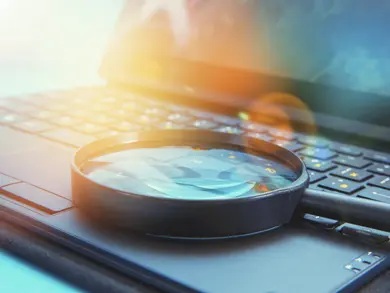 Magnifying glass laying on a computer