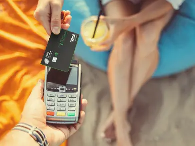 women paying for a drink on the beach