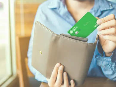 Person pulling Visa Debit card from wallet.